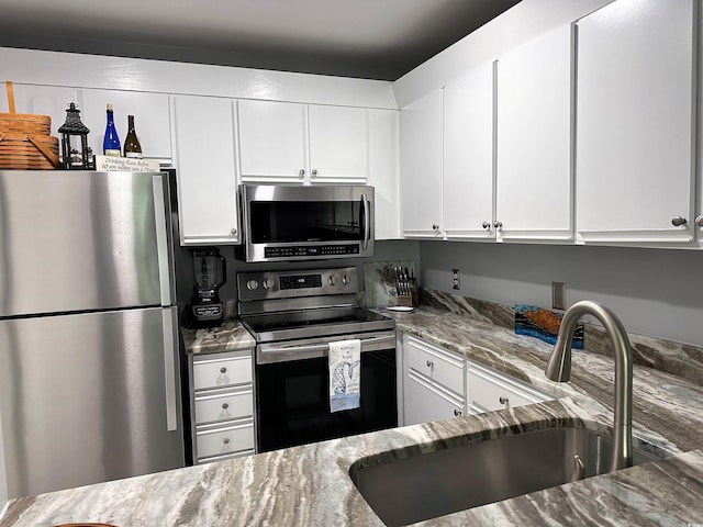 435 Ocean Creek Dr Unit 2731, Myrtle Beach, SC 29572 - kitchen featuring appliances with stainless steel finishes, light stone counters, and white cabinetry