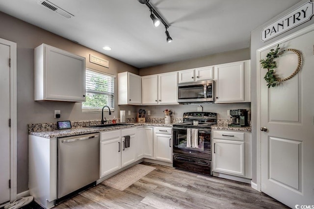780 Trap Shooter Cir, Longs, SC 29568 - kitchen with stainless steel appliances, white cabinetry, light wood-style flooring, light stone counters, and recessed lighting