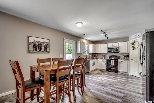 780 Trap Shooter Cir, Longs, SC 29568 - dining area featuring light wood-type flooring and rail lighting