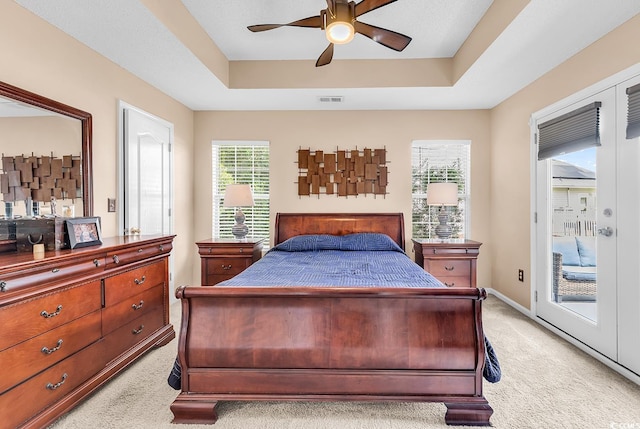 7977 Leeward Ln, Murrells Inlet, SC 29576 - bedroom featuring light colored carpet, access to exterior, multiple windows, and a tray ceiling