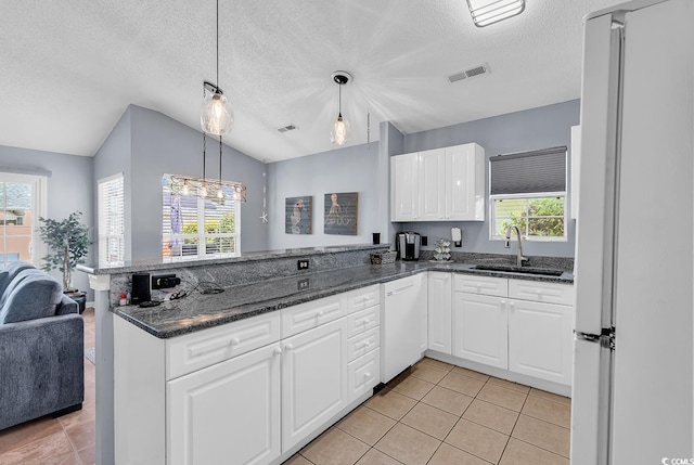 7977 Leeward Ln, Murrells Inlet, SC 29576 - kitchen with white appliances, a peninsula, white cabinetry, lofted ceiling, and light tile patterned floors