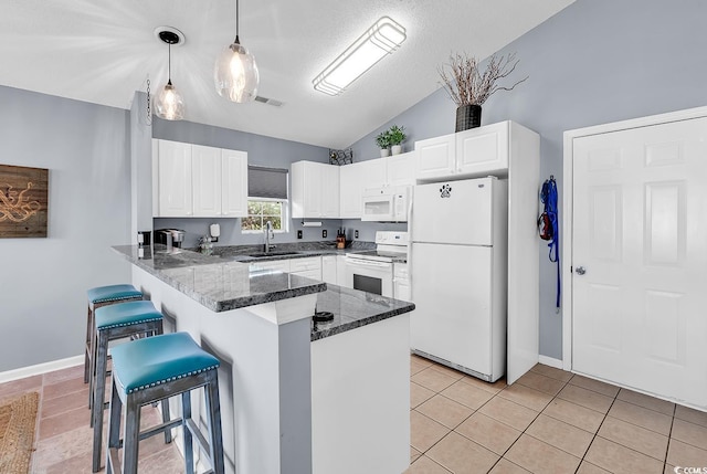 7977 Leeward Ln, Murrells Inlet, SC 29576 - kitchen with white appliances, lofted ceiling, a breakfast bar area, a peninsula, and dark stone countertops