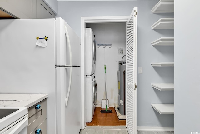4350 Intracoastal Dr Unit 1403, Little River, SC 29566 - kitchen with stacked washing machine and dryer, freestanding refrigerator, open shelves, and light stone countertops