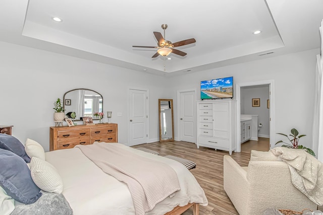 143 Enclave Pl, Pawleys Island, SC 29585 - bedroom featuring a raised ceiling, light wood finished floors, recessed lighting, ceiling fan, and ensuite bath