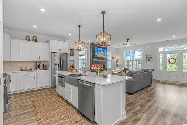 143 Enclave Pl, Pawleys Island, SC 29585 - kitchen with recessed lighting, stainless steel appliances, light countertops, white cabinets, and light wood-style flooring