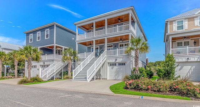 143 Enclave Pl, Pawleys Island, SC 29585 - coastal home with a ceiling fan, an attached garage, stairs, concrete driveway, and a porch