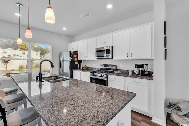 1404 Bellaria Way, Myrtle Beach, SC 29579 - kitchen featuring stainless steel appliances, dark wood finished floors, white cabinets, a kitchen island with sink, and a breakfast bar