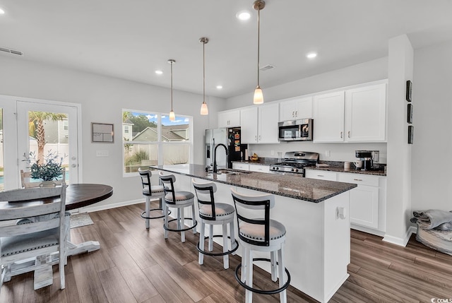 1404 Bellaria Way, Myrtle Beach, SC 29579 - kitchen with appliances with stainless steel finishes, a center island with sink, dark wood-style flooring, white cabinetry, and a breakfast bar