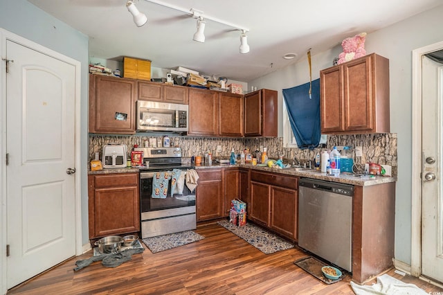 912 Clay Pigeon Ct, Longs, SC 29568 - kitchen featuring appliances with stainless steel finishes, dark wood-style flooring, backsplash, and brown cabinets