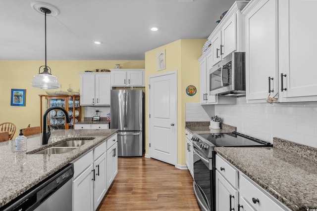 208 Forestbrook Cove Cir, Myrtle Beach, SC 29588 - kitchen featuring stainless steel appliances, white cabinets, hanging light fixtures, light wood finished floors, and decorative backsplash