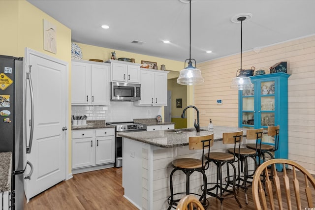 208 Forestbrook Cove Cir, Myrtle Beach, SC 29588 - kitchen with stainless steel appliances, wood finished floors, a kitchen breakfast bar, white cabinetry, and recessed lighting