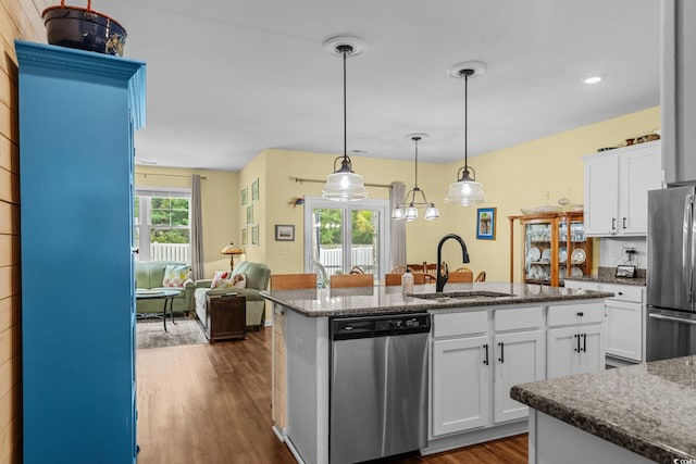 208 Forestbrook Cove Cir, Myrtle Beach, SC 29588 - kitchen featuring appliances with stainless steel finishes, dark wood-style floors, a center island with sink, white cabinetry, and decorative light fixtures