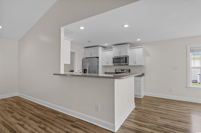 104 Fox Trot Dr, Galivants Ferry, SC 29544 - kitchen featuring appliances with stainless steel finishes, wood finished floors, white cabinetry, recessed lighting, and a peninsula