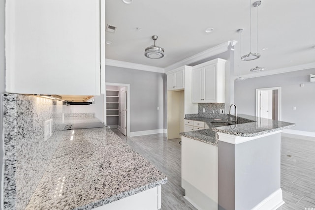 257 Venice Way Unit 2201, Myrtle Beach, SC 29577 - kitchen with crown molding, tasteful backsplash, light stone countertops, white cabinets, and a peninsula