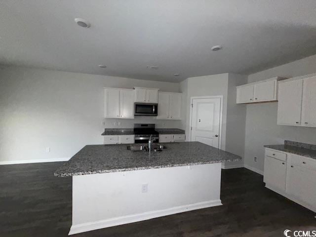2061 Ridgedale Dr, Conway, SC 29526 - kitchen with stainless steel microwave, stove, white cabinetry, and dark stone countertops