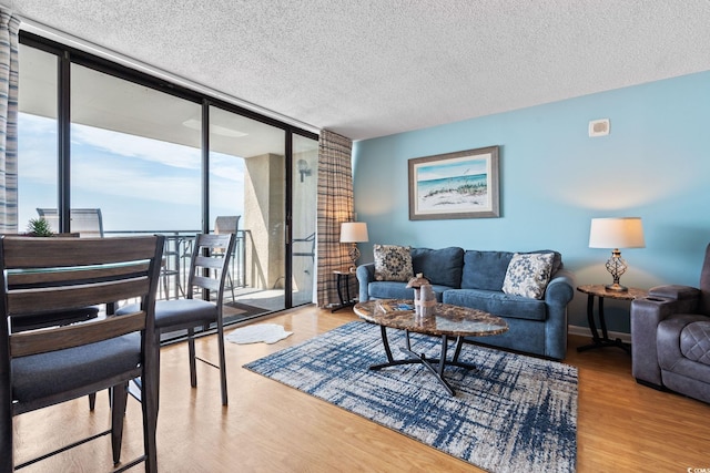 5523 N Ocean Blvd Unit 908, Myrtle Beach, SC 29577 - living room featuring a wall of windows, wood finished floors, and a textured ceiling