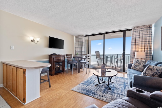5523 N Ocean Blvd Unit 908, Myrtle Beach, SC 29577 - living area with light wood-style floors, expansive windows, and a textured ceiling