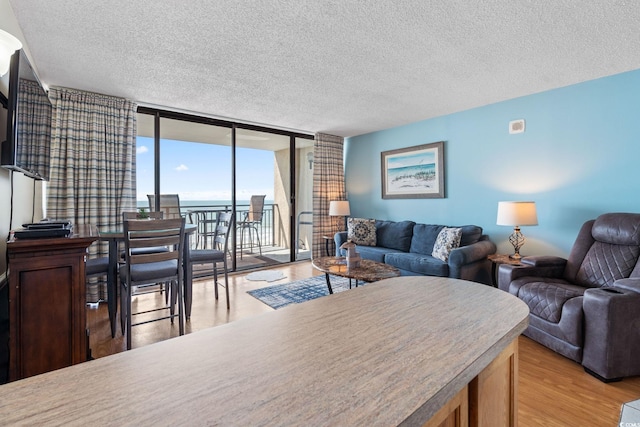 5523 N Ocean Blvd Unit 908, Myrtle Beach, SC 29577 - living area featuring a wall of windows, a textured ceiling, and light wood-style floors