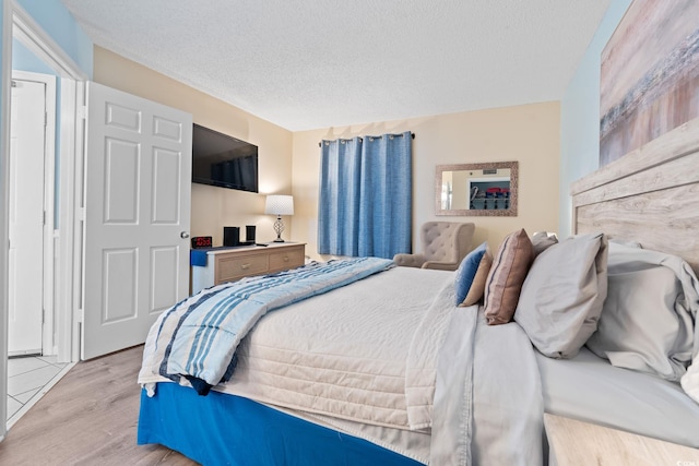 5523 N Ocean Blvd Unit 908, Myrtle Beach, SC 29577 - bedroom with light wood-style flooring and a textured ceiling