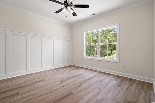 1712 26th Ave N, North Myrtle Beach, SC 29582 - empty room featuring a decorative wall, light wood-style floors, a ceiling fan, ornamental molding, and a wainscoted wall
