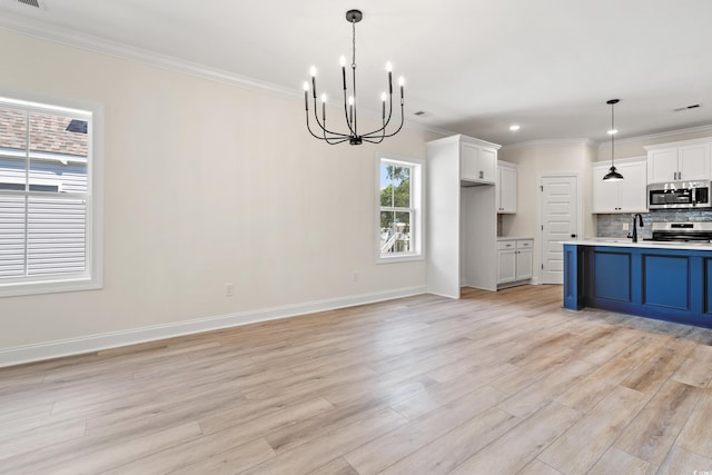 1712 26th Ave N, North Myrtle Beach, SC 29582 - kitchen with appliances with stainless steel finishes, crown molding, a chandelier, light countertops, and light wood finished floors