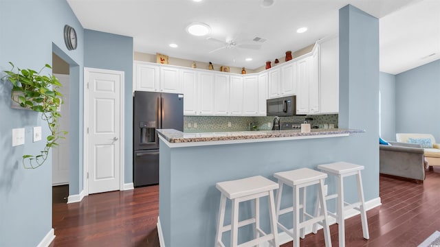 173 Knight Cir Unit 1, Pawleys Island, SC 29585 - kitchen with stainless steel fridge, black microwave, dark wood-type flooring, backsplash, and white cabinets