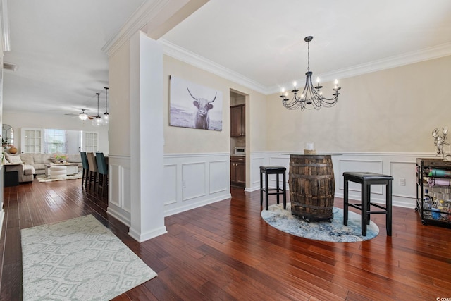 617 Carolina Farms Blvd, Myrtle Beach, SC 29579 - dining area featuring a chandelier, crown molding, a decorative wall, dark wood-type flooring, and a ceiling fan