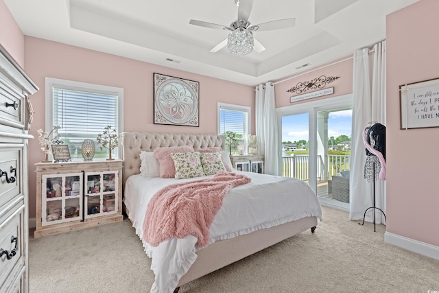 206 Palmetto Harbour Dr, North Myrtle Beach, SC 29582 - bedroom featuring a raised ceiling, access to outside, light carpet, a ceiling fan, and a water view
