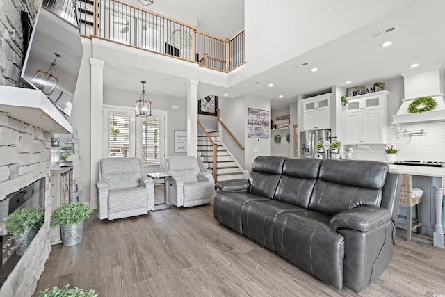 206 Palmetto Harbour Dr, North Myrtle Beach, SC 29582 - living area with stairs, a towering ceiling, light wood-style flooring, ornate columns, and a chandelier