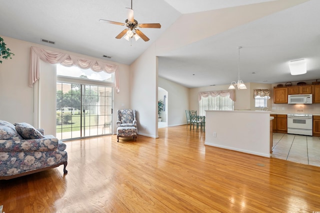 2443 Glen Dr, Little River, SC 29566 - living room with light wood finished floors, ceiling fan, arched walkways, high vaulted ceiling, and a chandelier