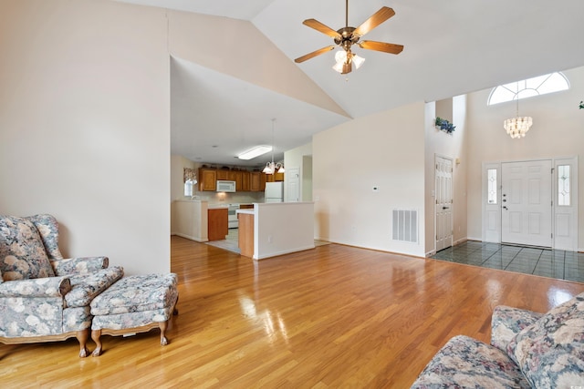 2443 Glen Dr, Little River, SC 29566 - living area featuring high vaulted ceiling, light wood-style flooring, a chandelier, and ceiling fan