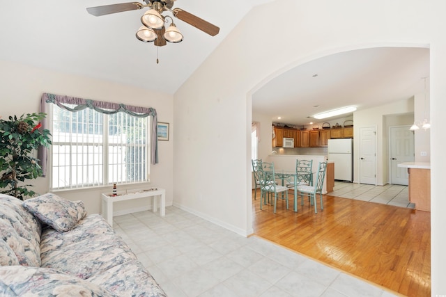 2443 Glen Dr, Little River, SC 29566 - living area with vaulted ceiling, a ceiling fan, arched walkways, and light tile patterned floors
