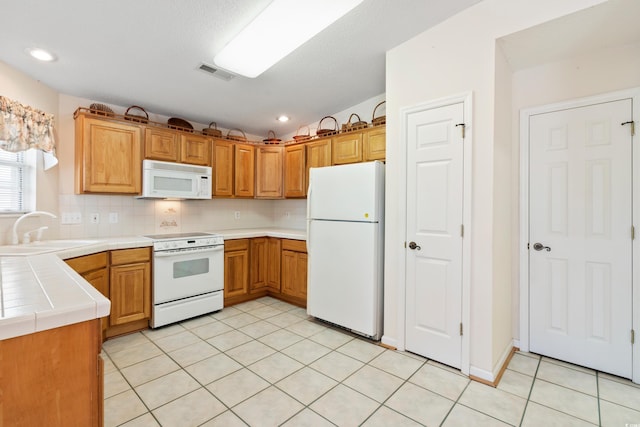 2443 Glen Dr, Little River, SC 29566 - kitchen with white appliances, tile counters, light tile patterned floors, decorative backsplash, and recessed lighting
