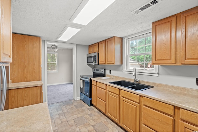 315 N River Pines Rd, Mullins, SC 29574 - kitchen featuring appliances with stainless steel finishes, a textured ceiling, light countertops, a ceiling fan, and light stone finish floors