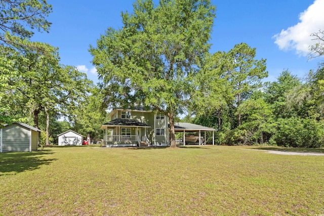 315 N River Pines Rd, Mullins, SC 29574 - view of grassy yard with a porch, a storage unit, and a carport