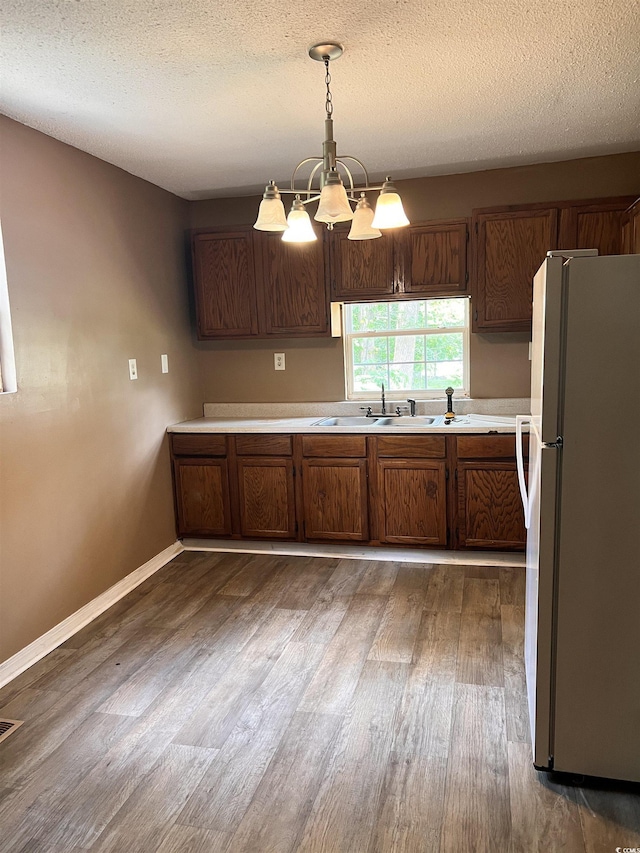 1706 Foster St, Conway, SC 29527 - kitchen featuring freestanding refrigerator, dark wood-style flooring, light countertops, a chandelier, and pendant lighting