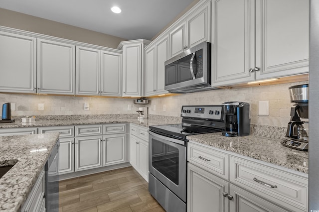 215 Vineyard Lake Cir, Conway, SC 29527 - kitchen with appliances with stainless steel finishes, white cabinetry, tasteful backsplash, and light stone countertops