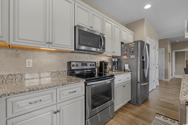 215 Vineyard Lake Cir, Conway, SC 29527 - kitchen with stainless steel appliances, white cabinets, decorative backsplash, light wood finished floors, and light stone counters