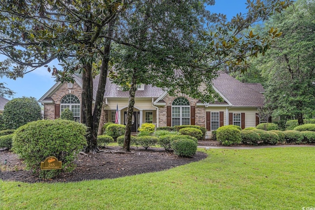 285 Georgetown Dr, Pawleys Island, SC 29585 - view of property hidden behind natural elements featuring a front lawn, brick siding, and roof with shingles