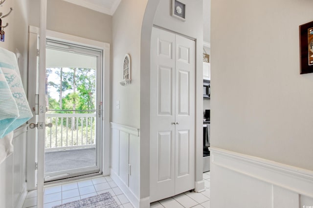 4179 Hibiscus Dr Unit 12-301, Little River, SC 29566 - entrance foyer with light tile patterned floors, arched walkways, ornamental molding, and a wainscoted wall