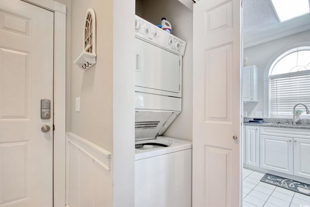 4179 Hibiscus Dr Unit 12-301, Little River, SC 29566 - laundry area with stacked washing machine and dryer, wainscoting, and light tile patterned floors