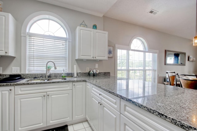4179 Hibiscus Dr Unit 12-301, Little River, SC 29566 - kitchen featuring light stone counters, white cabinetry, light tile patterned flooring, and a peninsula