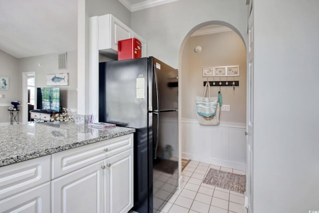 4179 Hibiscus Dr Unit 12-301, Little River, SC 29566 - kitchen with arched walkways, freestanding refrigerator, light tile patterned floors, white cabinets, and crown molding