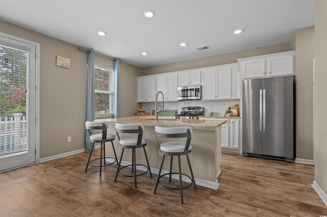 4737 Seclusion Ln, Myrtle Beach, SC 29577 - kitchen featuring appliances with stainless steel finishes, an island with sink, white cabinets, and recessed lighting