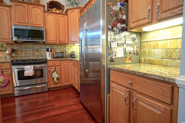 530 Inverarry St, Murrells Inlet, SC 29576 - kitchen with stainless steel appliances, dark wood-style floors, tasteful backsplash, light stone countertops, and brown cabinets