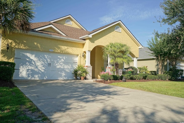 530 Inverarry St, Murrells Inlet, SC 29576 - view of front of home featuring stucco siding, a garage, concrete driveway, covered porch, and a front yard