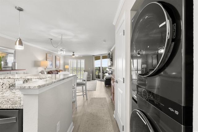 1819 N Ocean Blvd Unit 1518, North Myrtle Beach, SC 29582 - laundry area with stacked washer and clothes dryer, ceiling fan, light wood finished floors, and crown molding