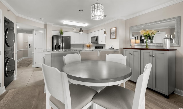 1819 N Ocean Blvd Unit 1518, North Myrtle Beach, SC 29582 - dining area featuring stacked washer and clothes dryer and ornamental molding