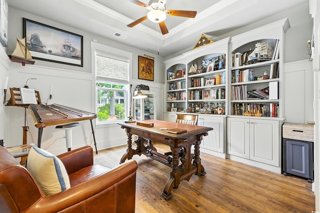 175 Chapel Creek Rd, Pawleys Island, SC 29585 - office area featuring a tray ceiling, light wood-style floors, crown molding, ceiling fan, and a decorative wall