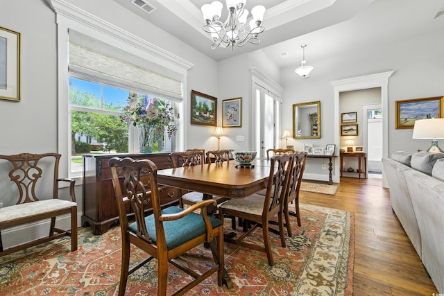 175 Chapel Creek Rd, Pawleys Island, SC 29585 - dining area featuring wood-type flooring, a chandelier, and a raised ceiling